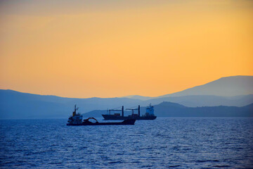 Obraz premium cargo ship travels at sunset