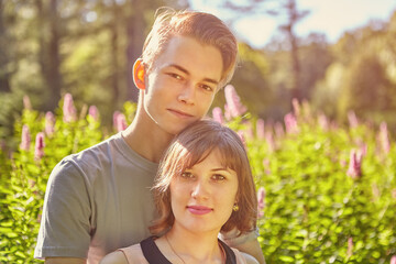 Fototapeta premium Close up portrait of young Caucasian couple on summer evening garden background.