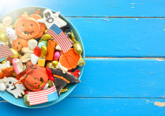 Halloween Jack o Lantern candy bowl with candy and halloween cookies Trick or Treat on patriotic american background, usa flag