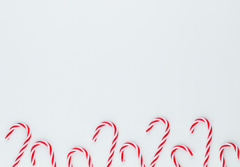 Christmas candy cane lied on blue background. Flat lay and top view.