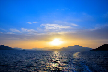 cargo ship travels at sunset
