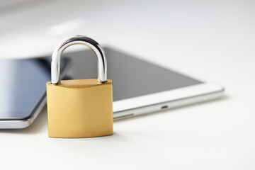Fototapeta premium tablet pc and smartphone with padlock over white background. digital data security concept. virus protection software concept