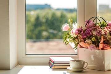 Fototapeta na wymiar romance and tenderness greeting card concept. mixed flowers bouquet and coffee cup on a window sill composition. copy space. take a brake conceptual