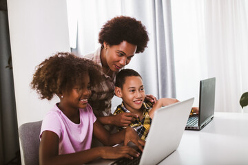 African American elementary students using computer and following classes online due to coronavirus pandemic.