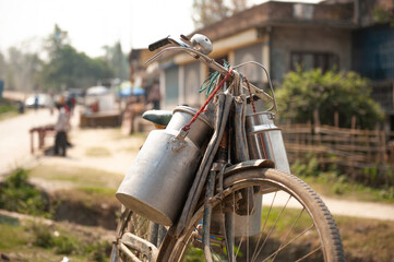 Fahrrad mit Milchkanne aus Aluminium an der Lenkstange. 