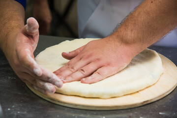 Professional chef prepares a closed meat pie