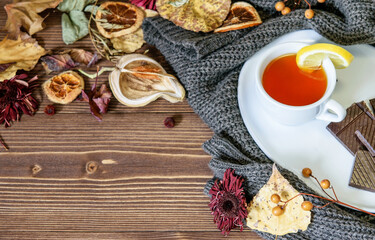 Autumn, fall colorful leaves, hot tea with lemon, chocolate on the warm textured pullover. Seasonal hot tea, weekend relaxing, life style concept.