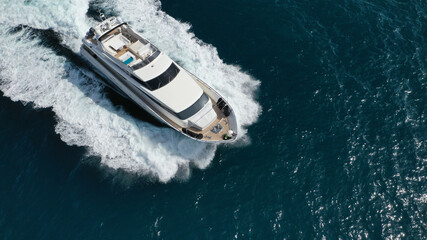 Fototapeta premium Aerial drone photo of small luxury yacht with wooden deck cruising open ocean deep blue sea