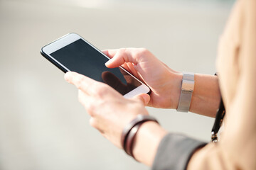 Hands of young elegant businesswoman with smartphone scrolling through contacts