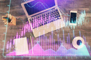 Double exposure of forex chart drawing over table background with computer. Concept of financial research and analysis. Top view.