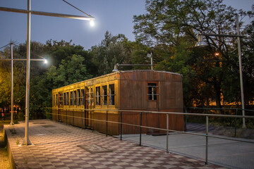 Old wooden carriages at night parked as an outdoor exhibition of railways in a park in the greek city of Kalamata. Outdoor railway museum in greece