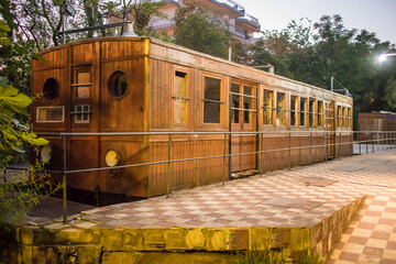 Old wooden carriages at night parked as an outdoor exhibition of railways in a park in the greek...