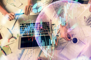 Double exposure of man and woman working together and financial graph hologram. Business concept. Computer background.