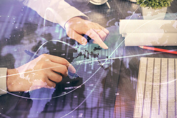 Double exposure of man's hands holding and using a phone and financial graph drawing. Analysis concept.