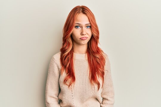 Young beautiful redhead woman wearing casual winter sweater depressed and worry for distress, crying angry and afraid. sad expression.