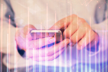 Multi exposure of man's hands holding and using a digital phone and forex graph drawing. Financial market concept.