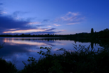 Symmetry of the sky in a lake at sunrise. Clouds reflecting on the water. Holiday landscape by the sea. Quiet relaxing scene.	