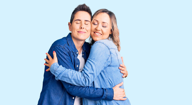 Couple of women wearing casual clothes hugging oneself happy and positive, smiling confident. self love and self care
