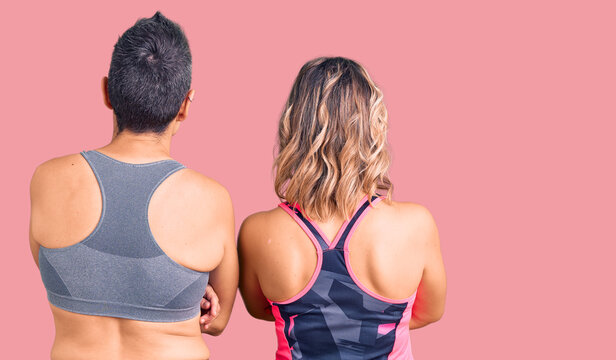 Couple of women wearing sportswear standing backwards looking away with crossed arms