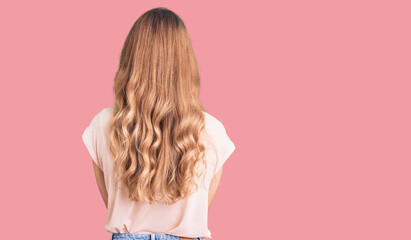 Young beautiful caucasian woman with blond hair wearing casual clothes standing backwards looking away with crossed arms