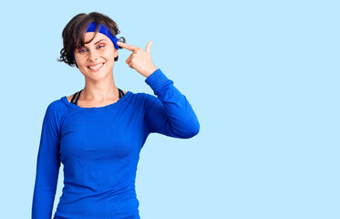 Beautiful young woman with short hair wearing training workout clothes smiling pointing to head with one finger, great idea or thought, good memory