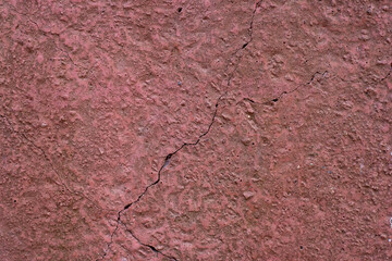 Pink plastered wall with a crack.