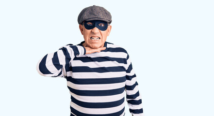 Senior handsome man wearing burglar mask and t-shirt cutting throat with hand as knife, threaten aggression with furious violence