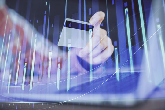Double exposure of man hands holding a credit card and Forex graph drawing. Stock trading and digital fintech in Internet E-commerce concept. - Powered by Adobe