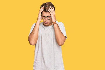 Handsome caucasian man wearing casual clothes and glasses suffering from headache desperate and stressed because pain and migraine. hands on head.