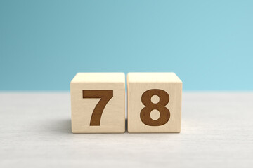 Wooden toy blocks forming the number 78.
