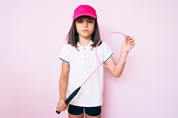 Young little girl with bang holding badminton racket skeptic and nervous, frowning upset because of problem. negative person.