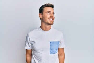 Fototapeta premium Handsome caucasian man wearing casual clothes looking to side, relax profile pose with natural face and confident smile.