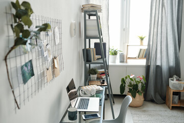 Workplace of remote student or freelancer consisting of table with supplies