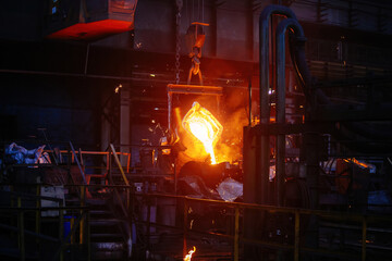Metal casting process in metallurgical plant. Liquid metal pouring into molds