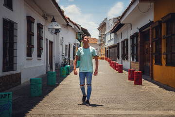 Naklejka premium portrait of young man walking down street of old house