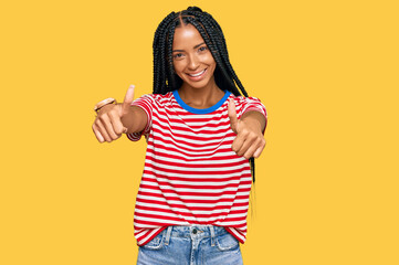 Beautiful hispanic woman wearing casual clothes approving doing positive gesture with hand, thumbs up smiling and happy for success. winner gesture.