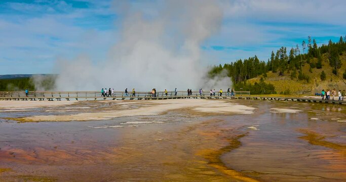 Yellowstone tourist boardwalk water geyser steam 4K. Wyoming, Montana and Idaho, USA. Geothermal geological environment ecosystem landscape. Biology geography and ecology.