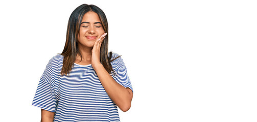 Obraz premium Young latin girl wearing casual clothes touching mouth with hand with painful expression because of toothache or dental illness on teeth. dentist