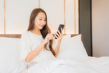 Obraz na płótnie Canvas Portrait beautiful young asian woman use smart mobile phone on bed