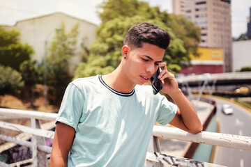 portrait of man talking on cell phone on bridge