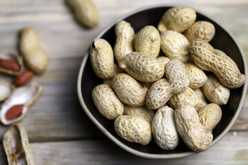 Peanuts in a peel in a bowl. Selective focus. Macro.