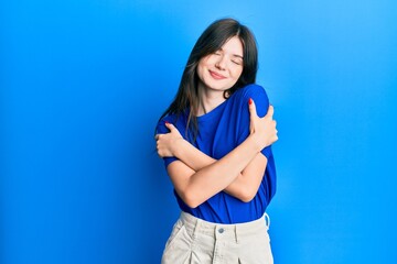 Fototapeta na wymiar Young beautiful caucasian girl wearing casual clothes hugging oneself happy and positive, smiling confident. self love and self care