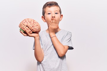 Cute blond kid holding brain covering mouth with hand, shocked and afraid for mistake. surprised...