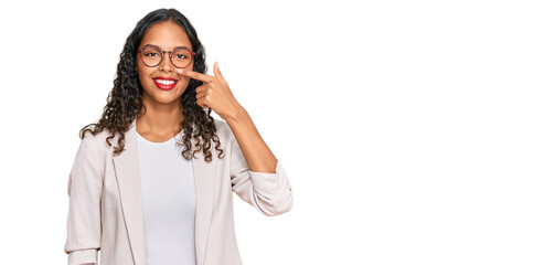 Young african american girl wearing business clothes pointing with hand finger to face and nose, smiling cheerful. beauty concept