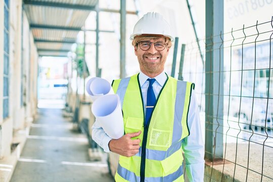 Business architect man wearing hardhat standing outdoors of a building project wearing reflective vest