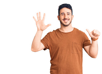 Young hispanic man wearing casual clothes showing and pointing up with fingers number six while smiling confident and happy.
