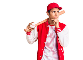 Young african amercian man playing baseball holding bat and ball serious face thinking about question with hand on chin, thoughtful about confusing idea