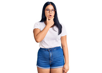Obraz premium Young beautiful asian girl wearing casual clothes and glasses looking fascinated with disbelief, surprise and amazed expression with hands on chin