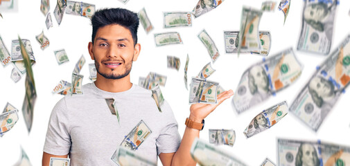 Handsome latin american young man wearing casual tshirt smiling cheerful presenting and pointing with palm of hand looking at the camera.