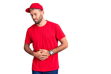 Young handsome blond man wearing t-shirt and cap with hand on stomach because indigestion, painful illness feeling unwell. ache concept.